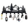 Black metal key holder with hooks shaped like a mountain forest silhouette