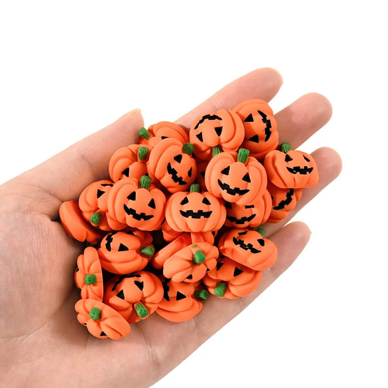 A hand holds a cluster of 20 orange resin pumpkin charms for fall decor.