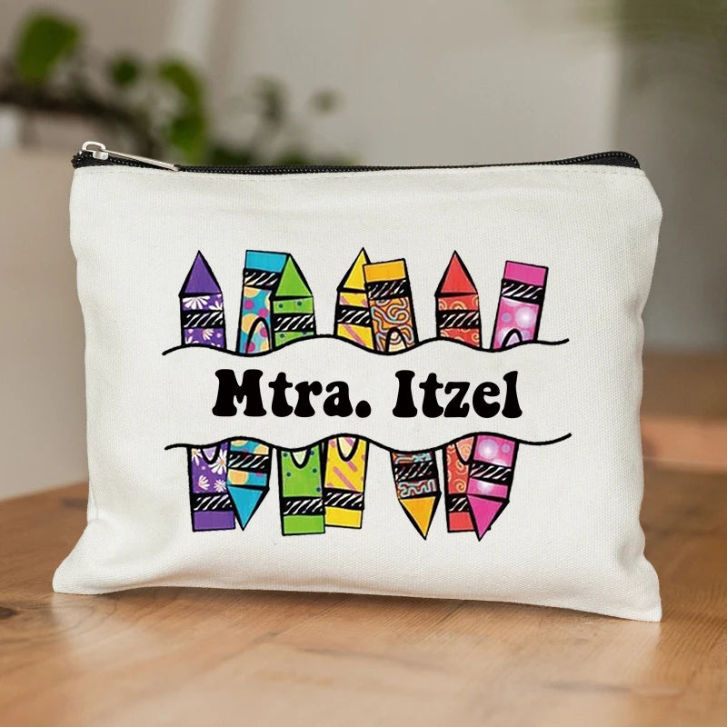 A white zippered pouch featuring colorful, patterned fabric shapes resembling houses and clothing items.
