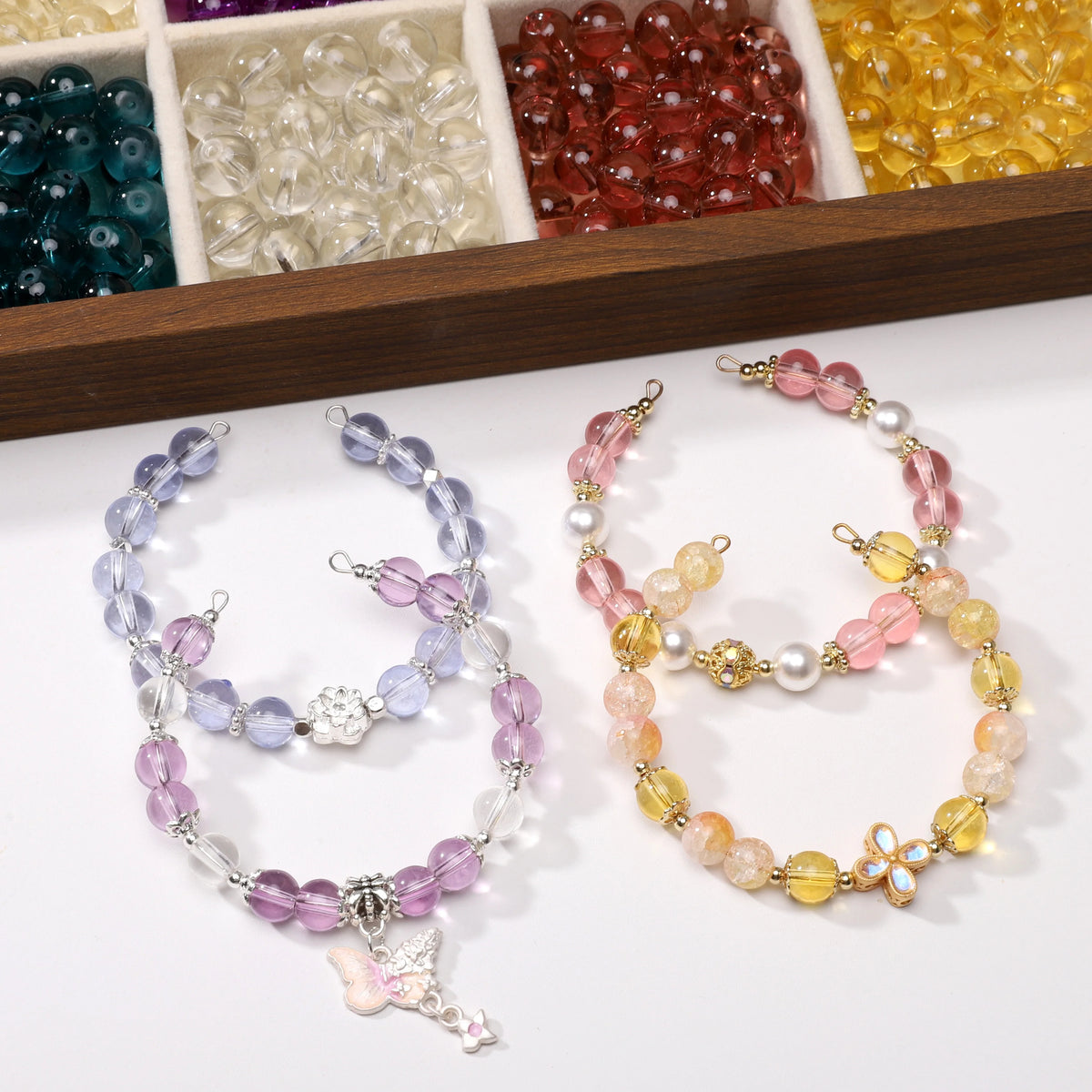 Two sets of round glass spacer beads in shades of purple pink and yellow for jewelry making