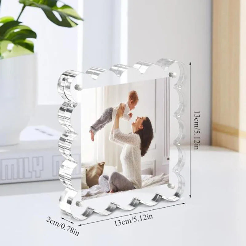 A clear acrylic photo display frame with a decorative border showing a person taking a picture of a child.