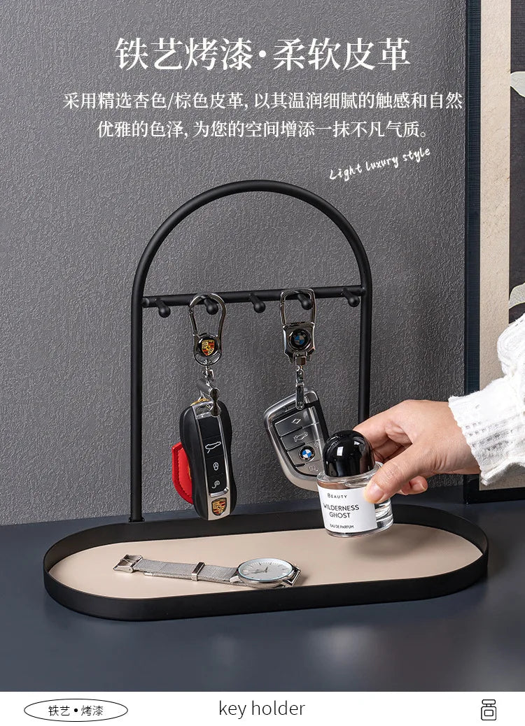 A black wrought iron key holder rack displaying various keys and a watch on a desk.