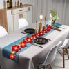 A table setting featuring a red poinsettia garland light display on a gray tablecloth.