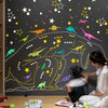 Glow-in-the-Dark Dinosaur Wall Stickers for Kids' Rooms displayed on a dark wall with various colorful dinosaur shapes.