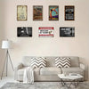 A collection of nine custom aluminum wall signs featuring various text and imagery on a light beige wall.