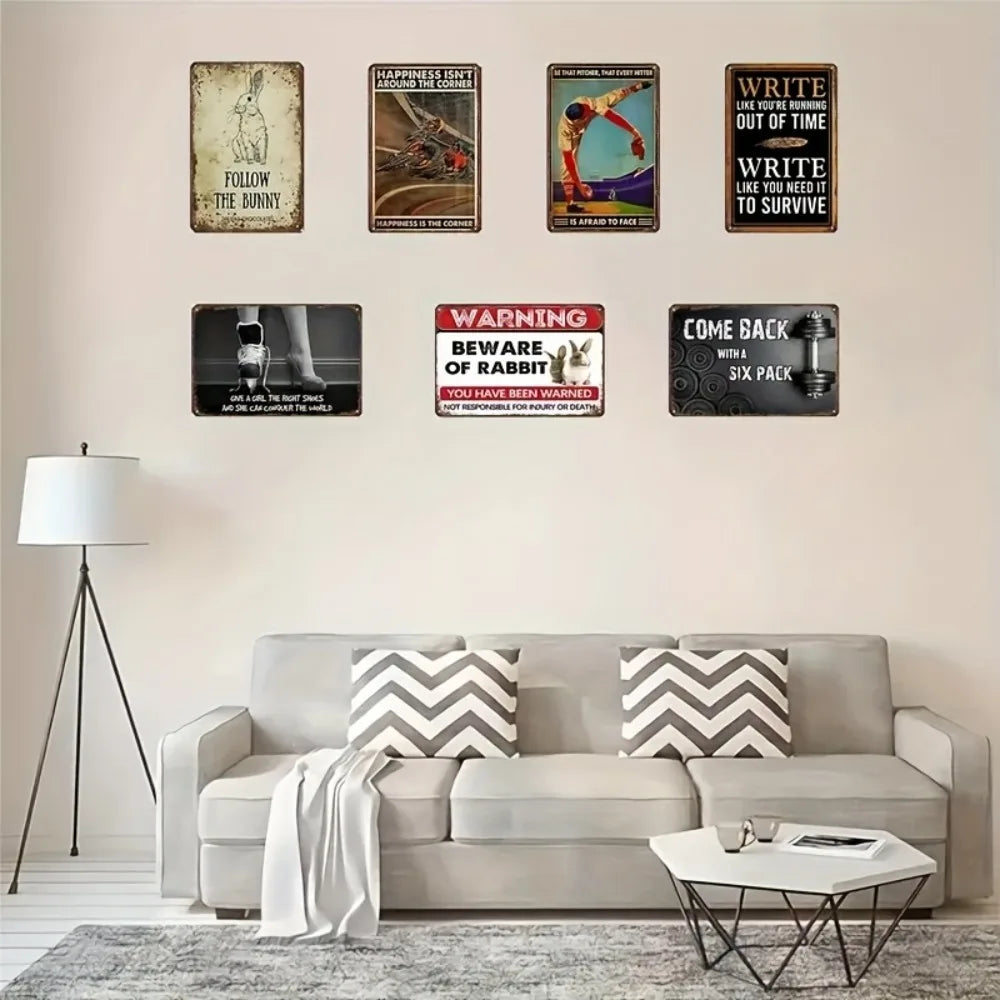 A collection of nine custom aluminum wall signs featuring various text and imagery on a light beige wall.