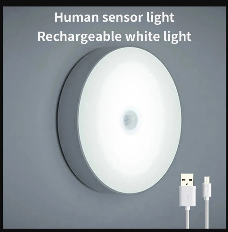 A white rechargeable human sensor light fixture mounted on a wall.