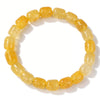 A bracelet made of small, round, yellow-orange citrine crystals strung together.