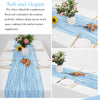 Light blue cheesecloth table runner with floral and centerpiece decorations on a white table.