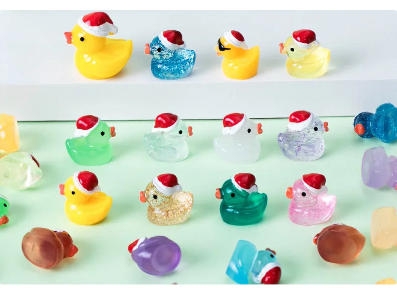 A collection of glow-in-the-dark duck figurines with Santa hats in various colors on a light green surface.