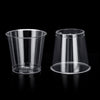 A clear plastic shot glass is shown against a black background.