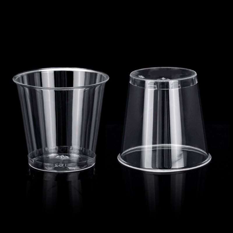 A clear plastic shot glass is shown against a black background.