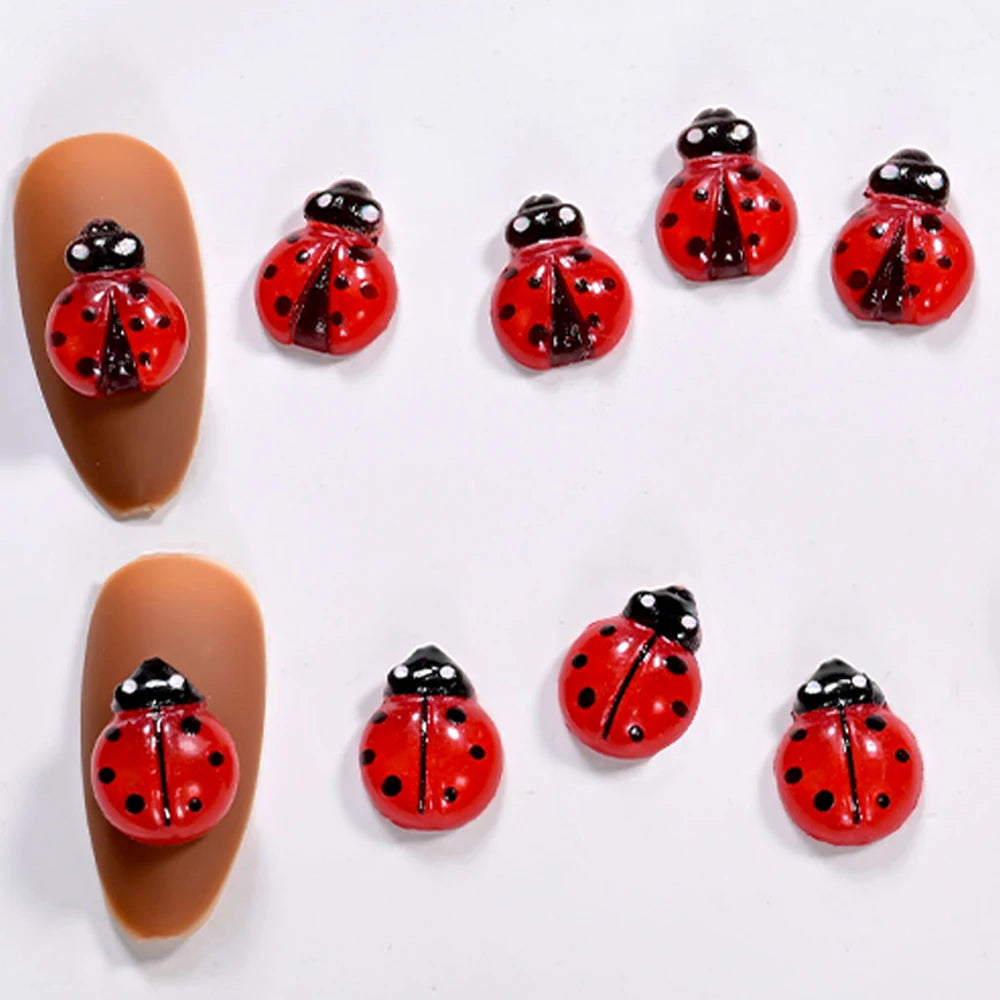 A collection of 3D resin ladybug nail art charms in red and black on a white background.