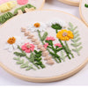 Punch needle embroidery kit featuring a floral design with white, yellow, and pink flowers on natural cloth.