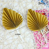 Two golden palm leaf cake toppers with pleated texture displayed on a white mesh background.
