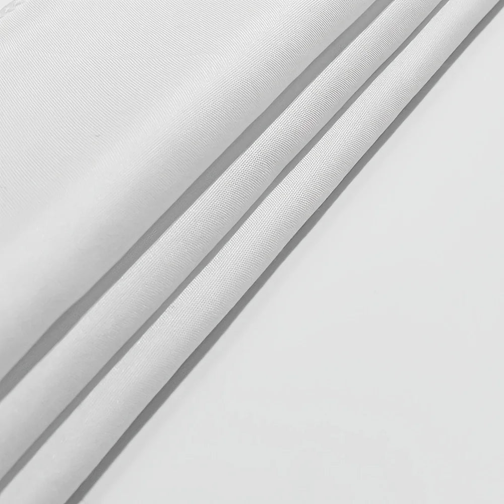 A close-up of white fabric or tapestry with subtle vertical lines, folded and draped.