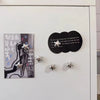 A display of decorative fridge magnets featuring silver star designs and a black circular text magnet.