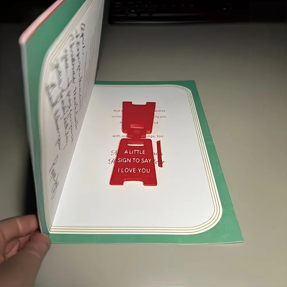 A close-up of a green and white letter sign ornament with red text that reads I love you