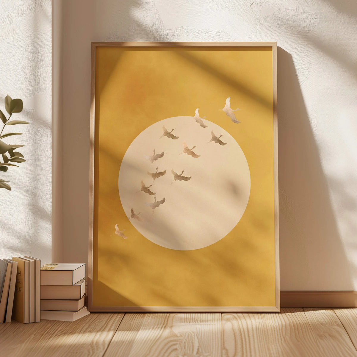 A framed piece of Japanese crane canvas wall art featuring a circular design with delicate cranes on a mustard yellow backgro