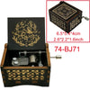A wooden music box with a lid featuring an illustrated deer and foliage, showing the interior mechanism.