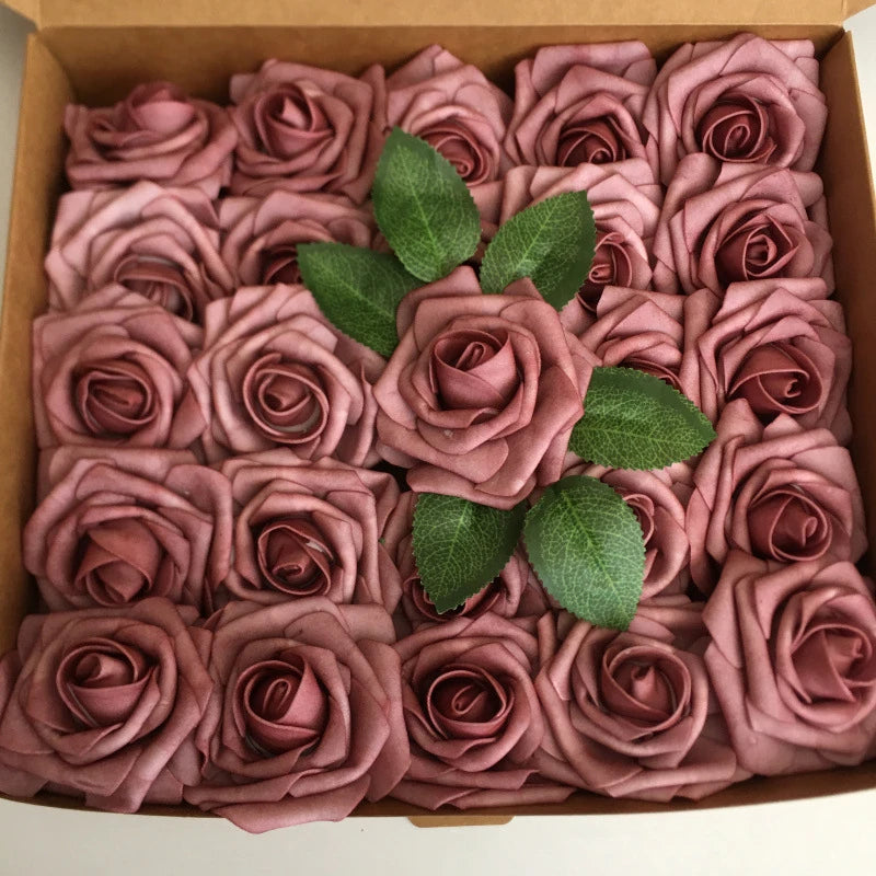A box filled with artificial real touch foam roses in various shades of dusty rose and mauve.