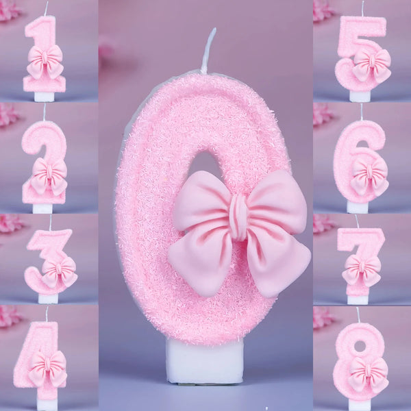Glittery pink number birthday candles with decorative bows forming the number six.