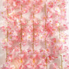 Pink cherry blossom string lights garland with glowing blossoms hanging vertically