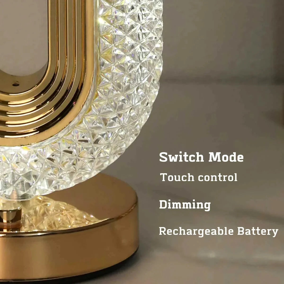 A close-up view of an oval crystal LED table lamp with a gold finish and diamond-cut glass shade.