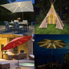 A patio umbrella light with a gold-toned shade illuminating a dark blue ocean view at night.