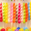 Assorted latex balloons in various colors like pink, yellow, green, and orange are displayed hanging and on the ground.