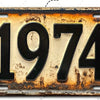 Señal de pared de aluminio vintage con el año 1974 grabado, mostrando signos de envejecimiento y pátina.