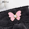 Pink butterfly with a pearl center attached to a black denim fabric.