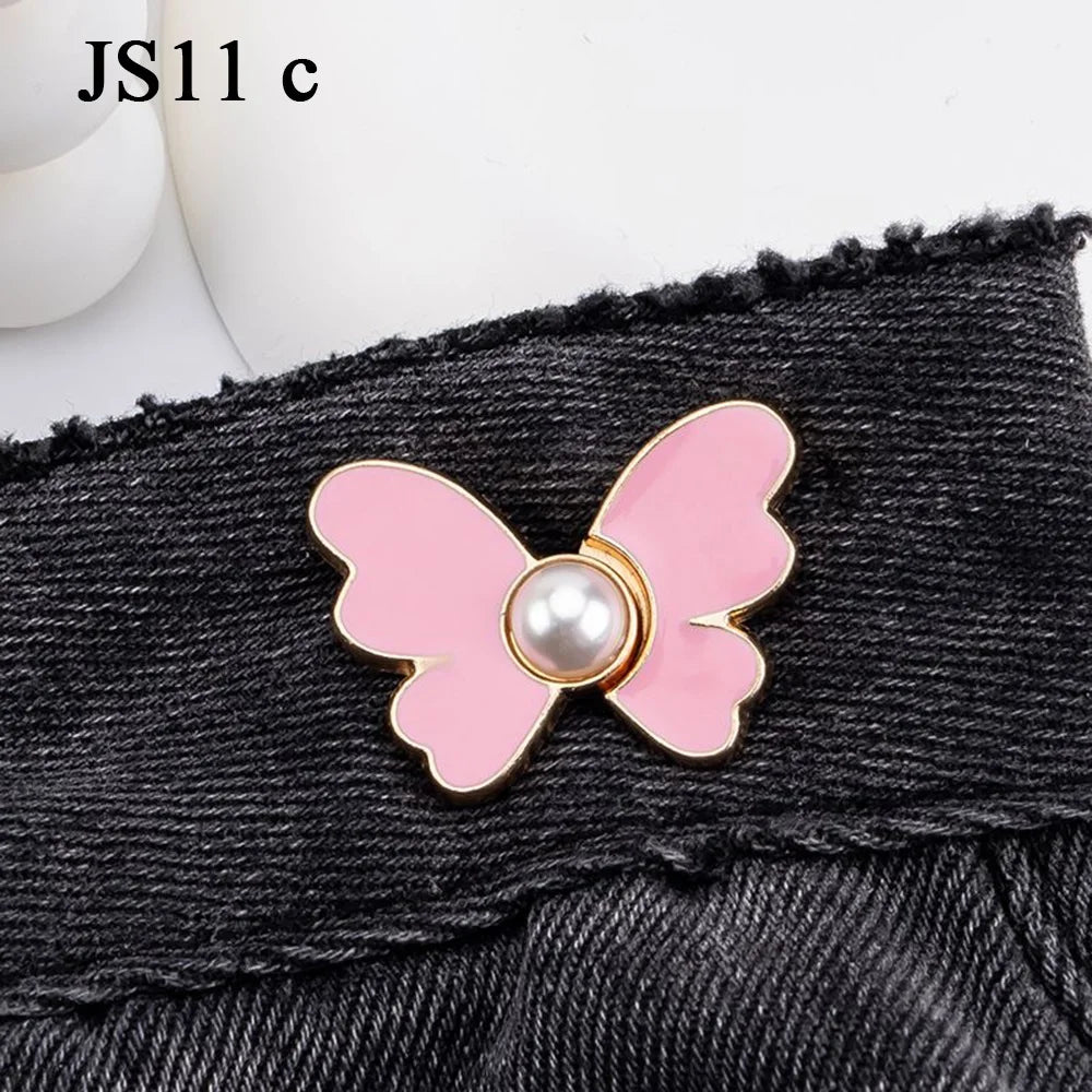 Pink butterfly with a pearl center attached to a black denim fabric.