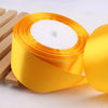 Roll of gold yellow satin ribbon with white filling for crafts and gift wrapping