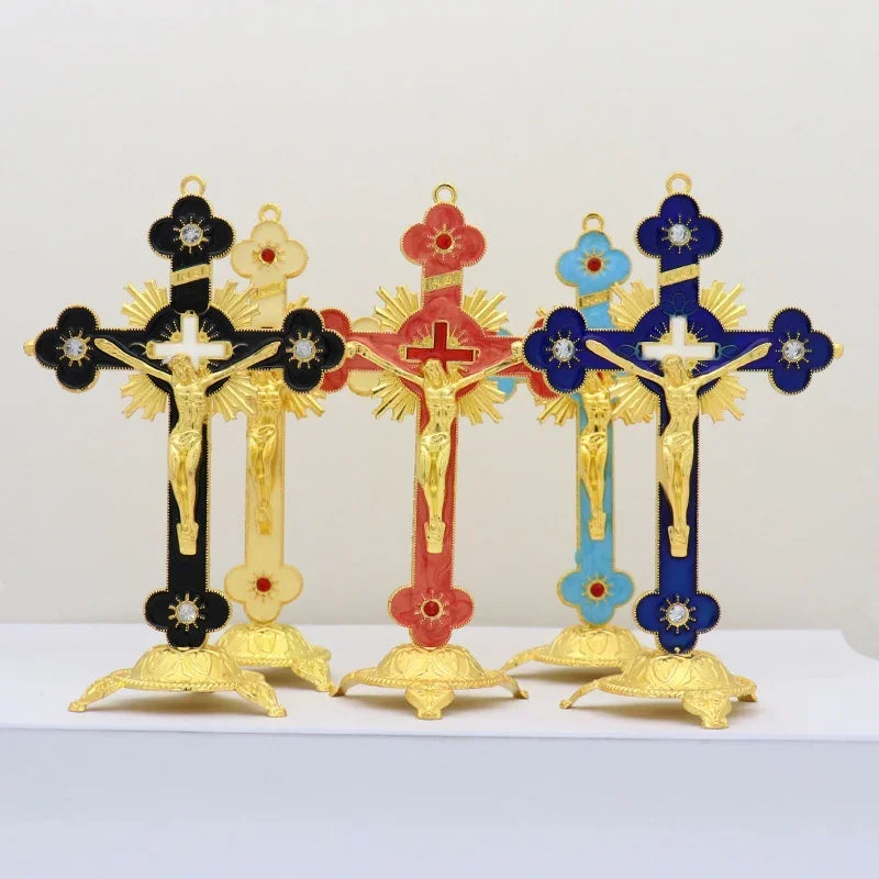 A set of four antique-style crucifix figurines with gold and colored crosses on black stands.