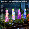 Four colorful solar-powered delphinium flower lights illuminating a garden in bad weather.