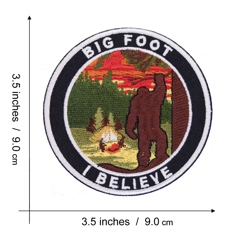 An embroidered circular patch featuring a silhouette of Bigfoot standing in a forest with text reading Big Foot I Believe