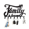 Black decorative metal wall-mounted key holder with seven hooks hanging against a white background