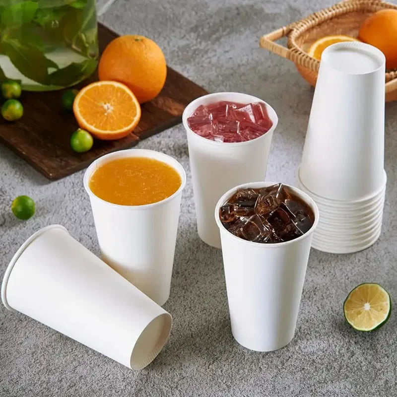 A collection of white disposable paper coffee cups filled with various beverages, including orange juice and red liquid.
