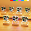 Seven colored acrylic heart photo frames displaying couples and text on a wooden surface.
