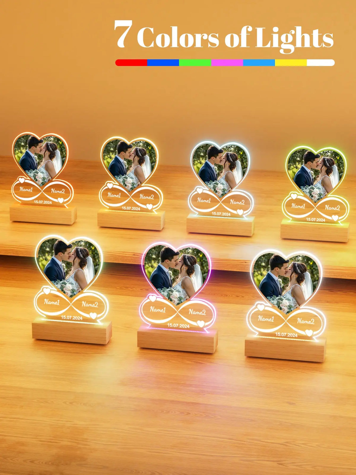 Seven colored acrylic heart photo frames displaying couples and text on a wooden surface.