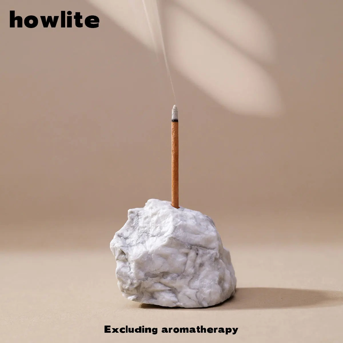 A clear quartz crystal is placed on a light-colored surface with a thin stick, suggesting an incense or aromatherapy product.