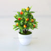 Artificial lemon tree bonsai with green leaves and yellow-orange fruit planted in a white pot