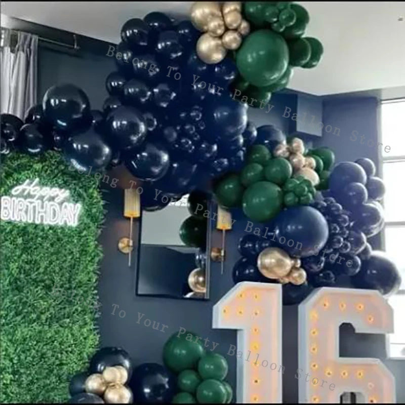 A dark background features a balloon garland with black, gold, and green balloons, decorated for a birthday.