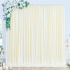 A floor-to-ceiling cream fabric backdrop with vertical pleats and greenery accents.
