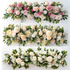 A floral arrangement of artificial white and pink roses and greenery for event decor.