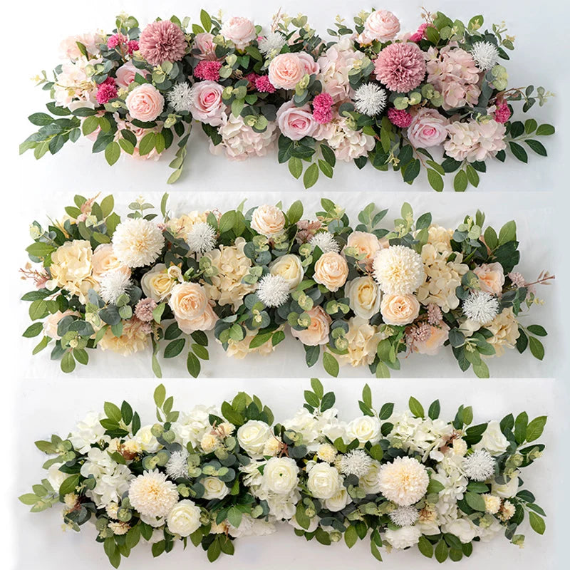 A floral arrangement of artificial white and pink roses and greenery for event decor.