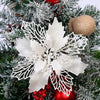White glittery snowflake ornament on a green Christmas tree branch