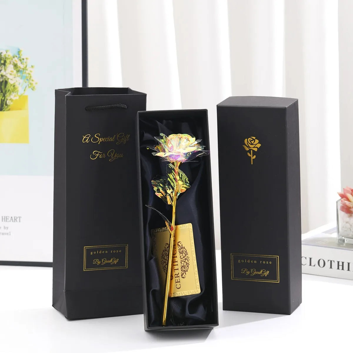 A black gift box set featuring a metallic foil rose flower, card, and display box.