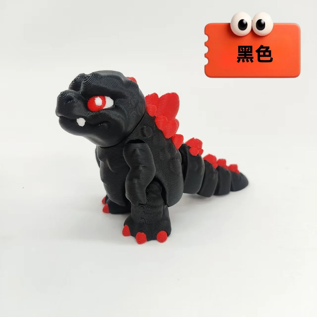 A black collectible 3D printed Godzilla sitting figure with red accents, displayed next to an orange tag labeled Black.